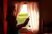 Girl Holding Book Looking Out Window free creative commons